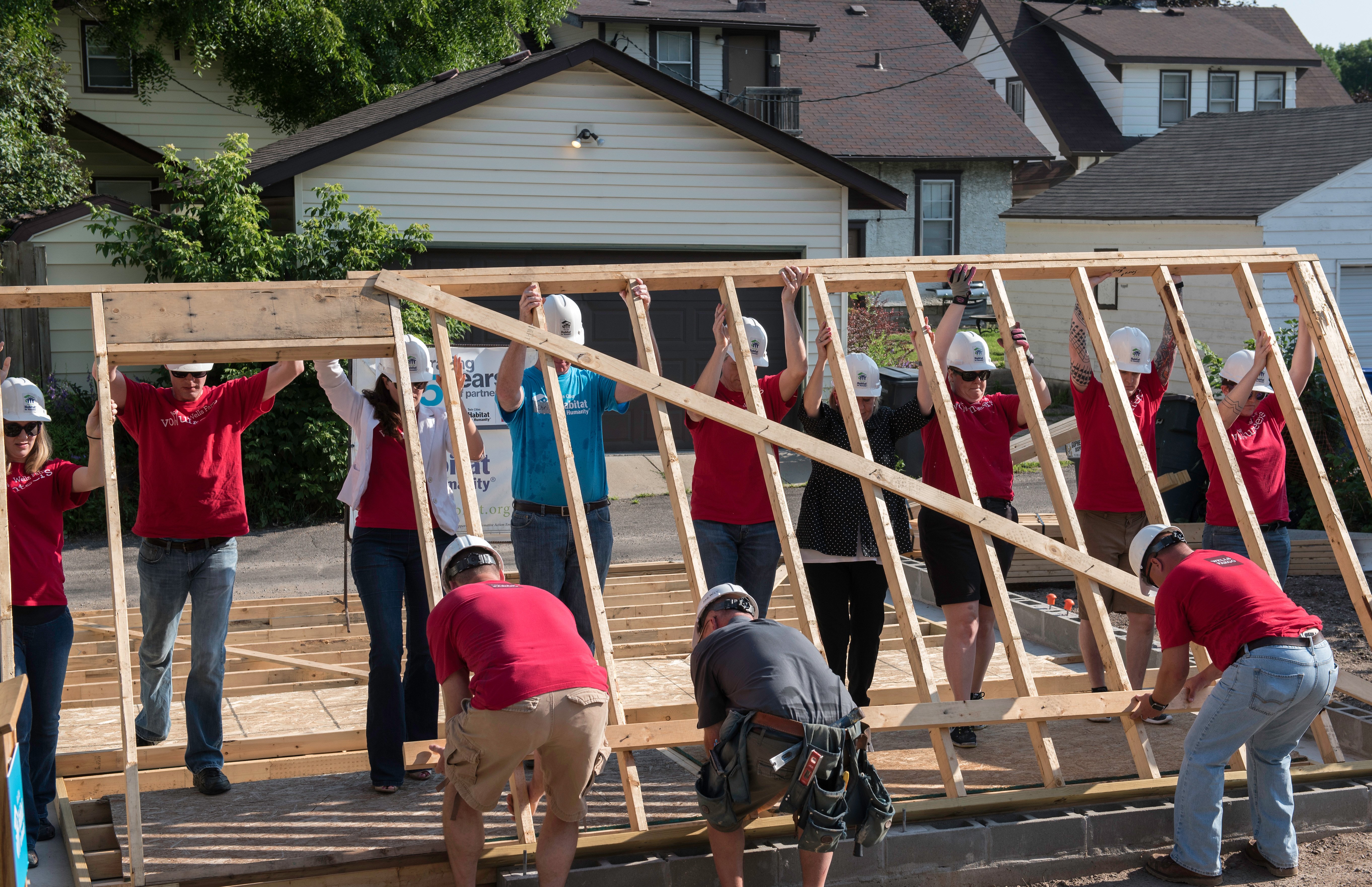 volunteers raising a wall