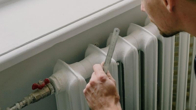 A person fixing a radiator.