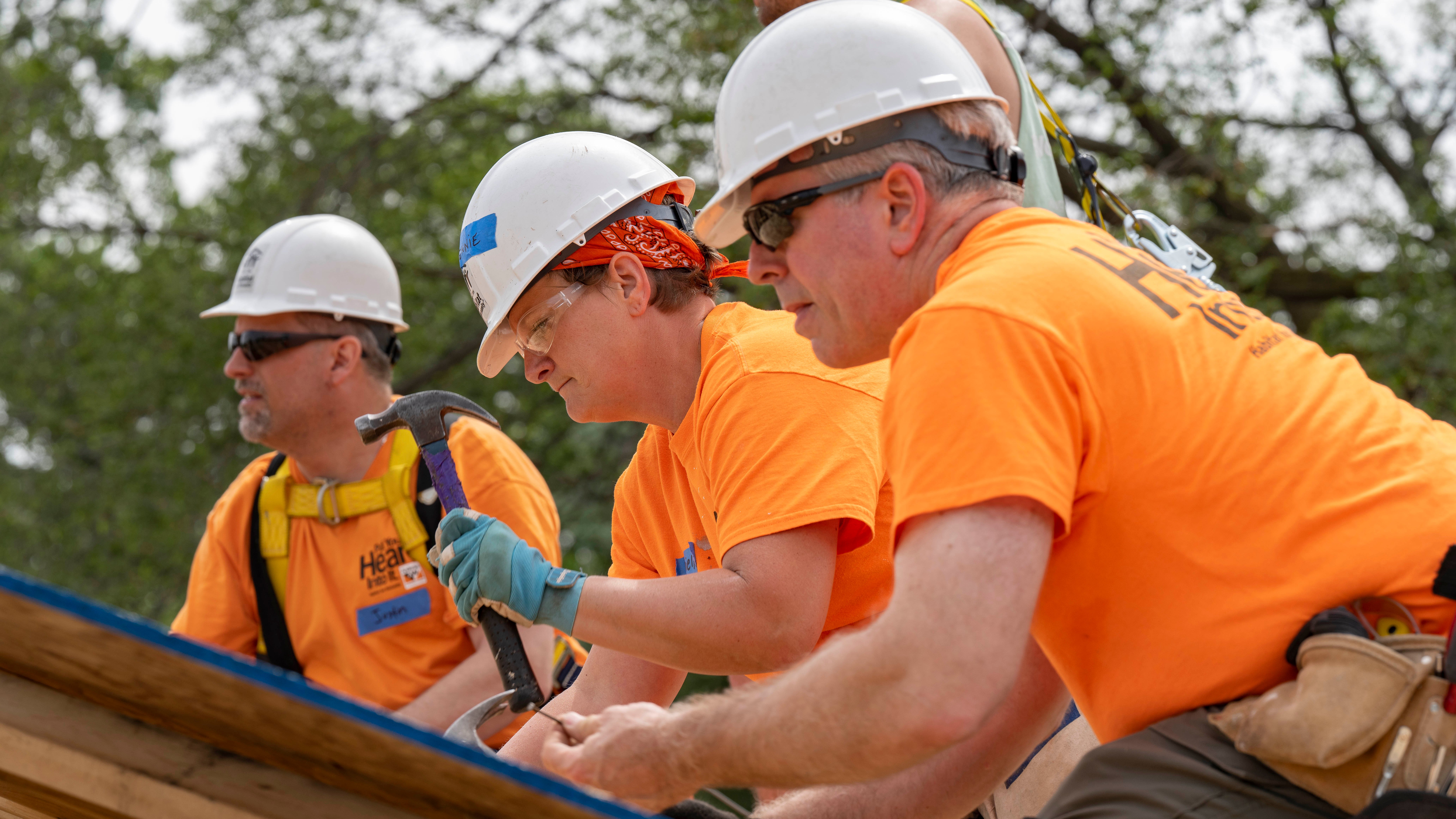 Volunteers hammering.