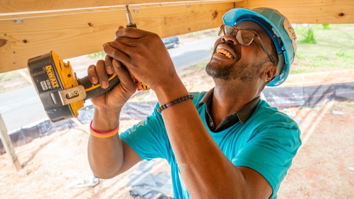 Volunteer using a drill on site.