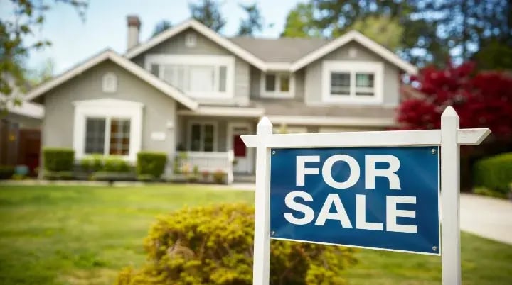 For Sale sign in front of house.