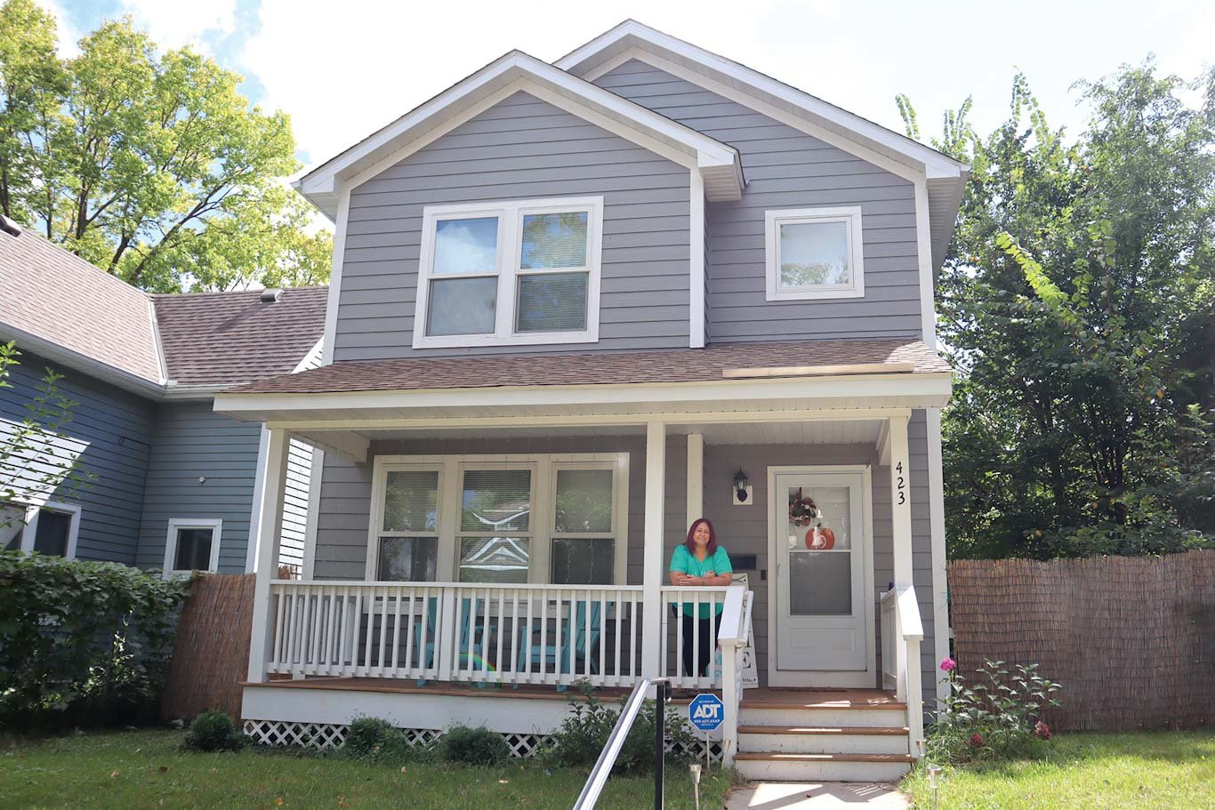 Michelle standing on the porch, showing her entire Habitat home.