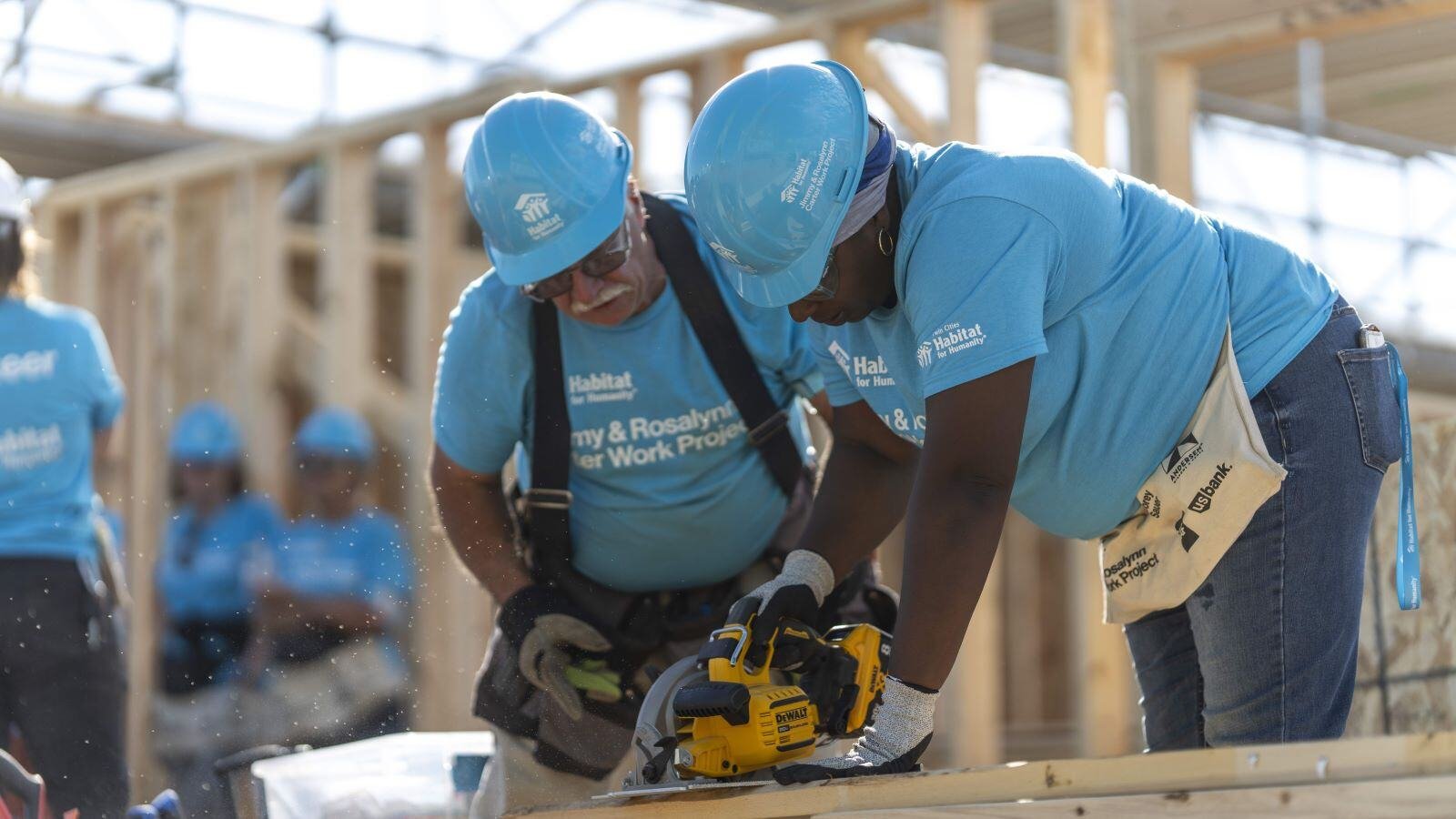 Two volunteers use a saw at the 2024 Carter Work Project.