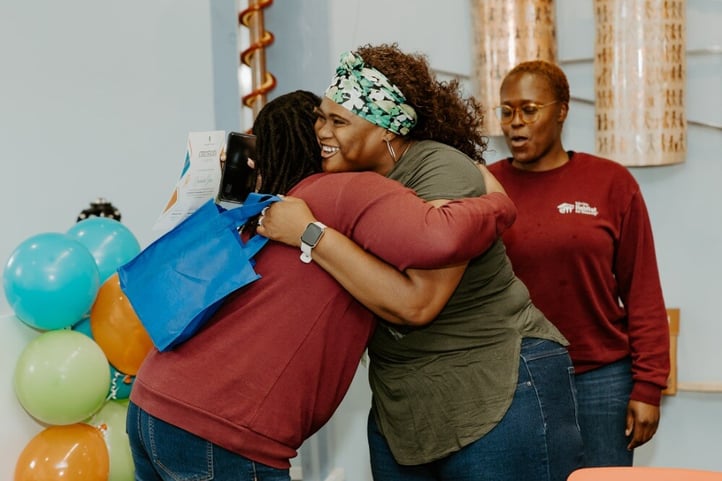 Participant gets a hug at graduation.