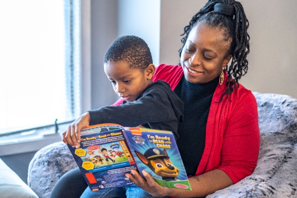 Habitat homeowner reading a book with her young son.