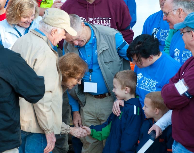 Rosalynn Carter shaking child's hand.