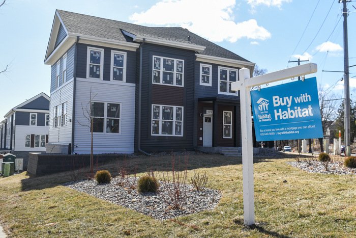 A Habitat home with a Buy with Habitat sign in front