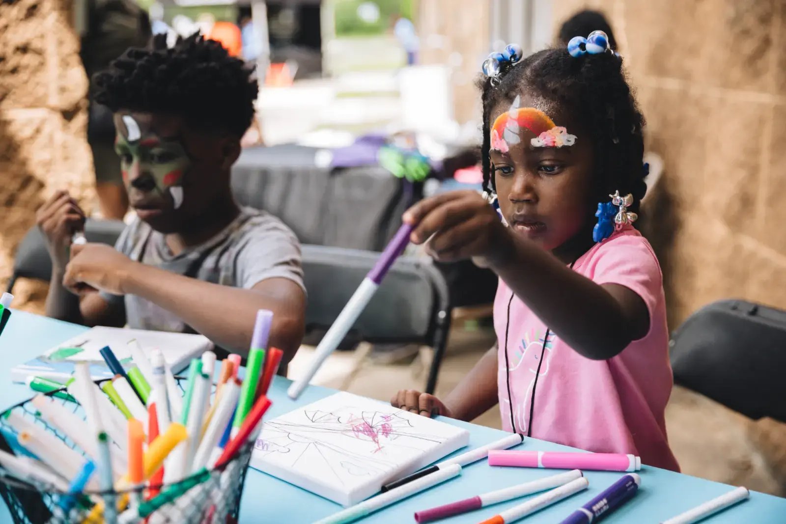 Kids wearing face paint are coloring