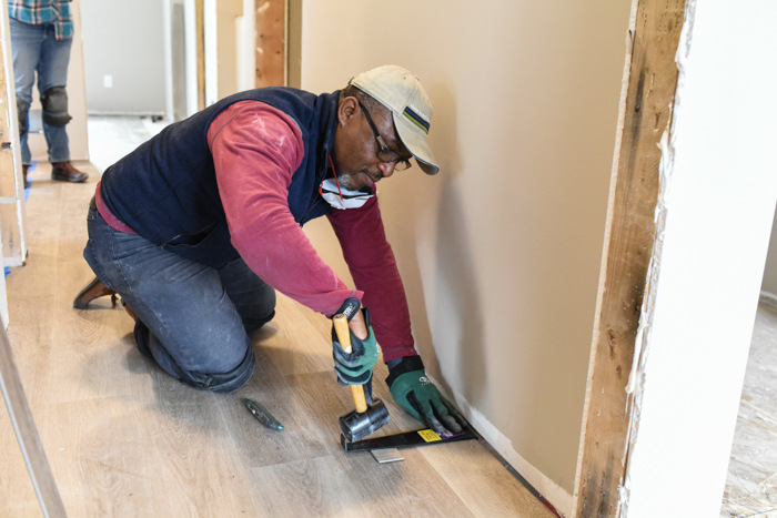 Edgar works on flooring at Volunteer and Learn skill build